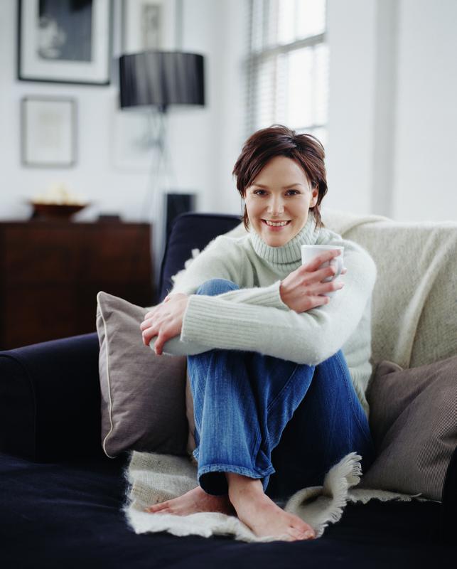 Woman sitting on couch drinking coffee after Individual Counseling session